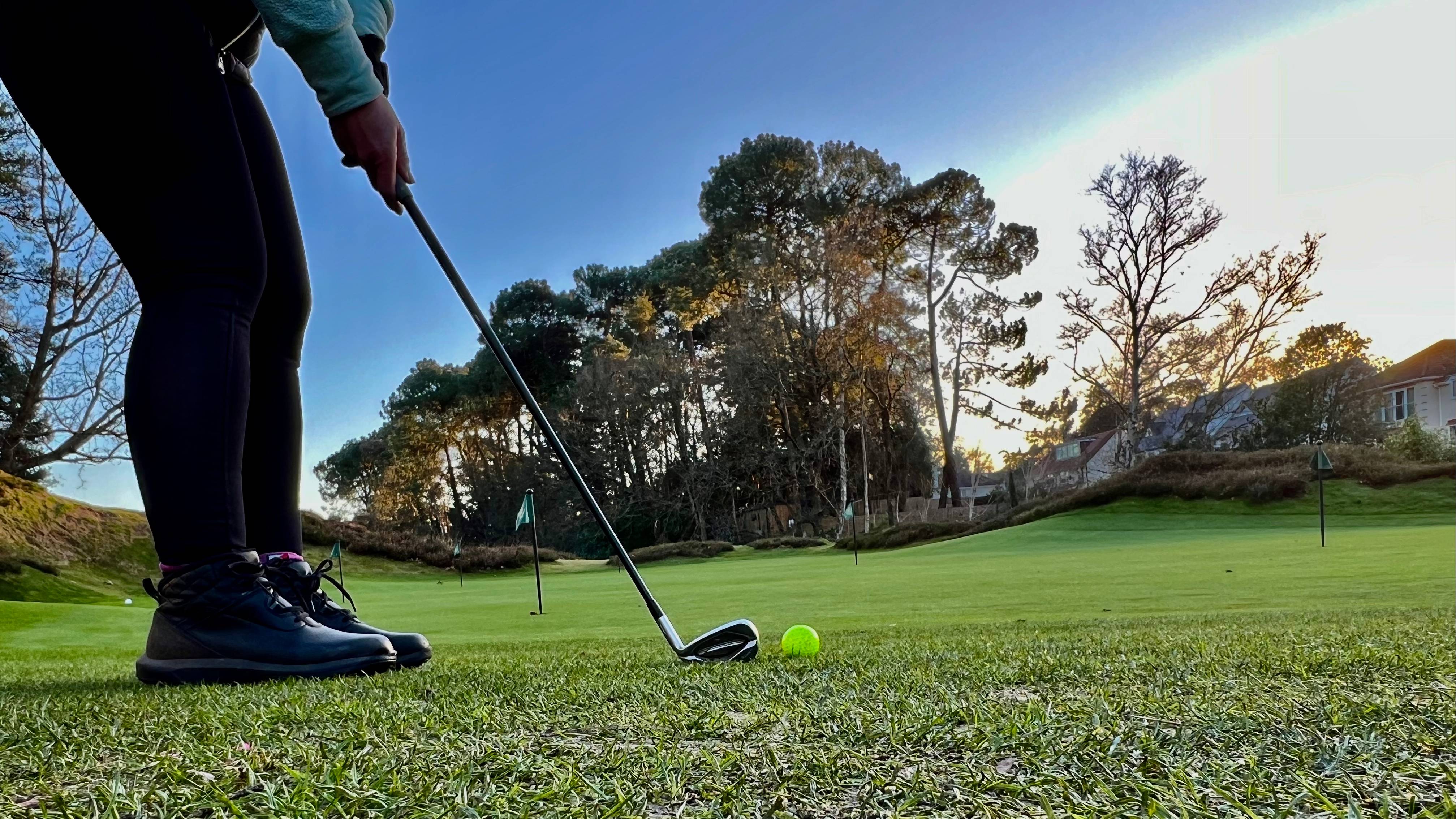 Golfer addressing yellow golf ball