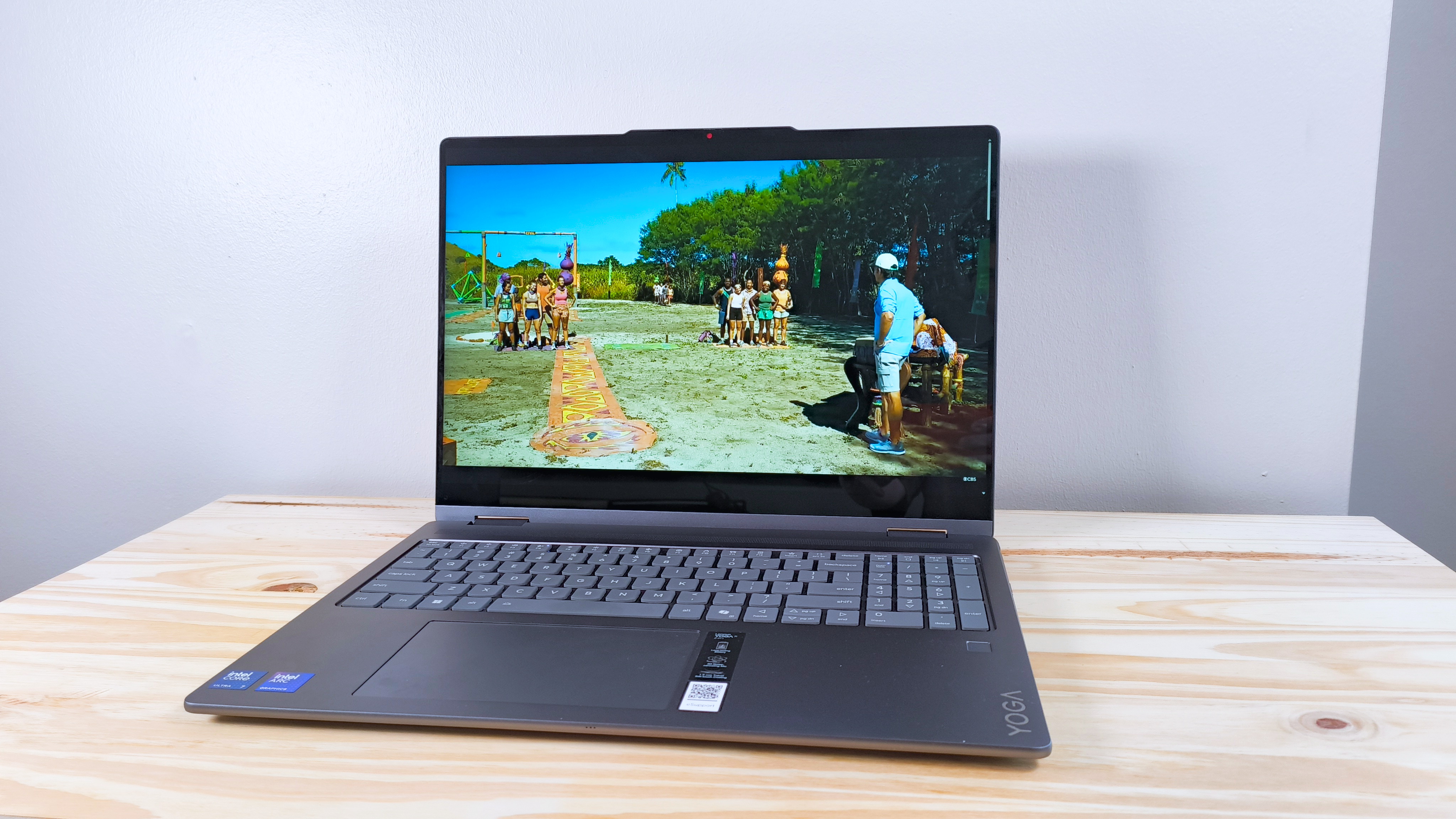 The Lenovo Yoga 7i 2-in-1 16 on a wood table playing an episode of Survivor 48 (CBS)
