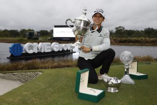Lydia Ko poses next to lots of trophies