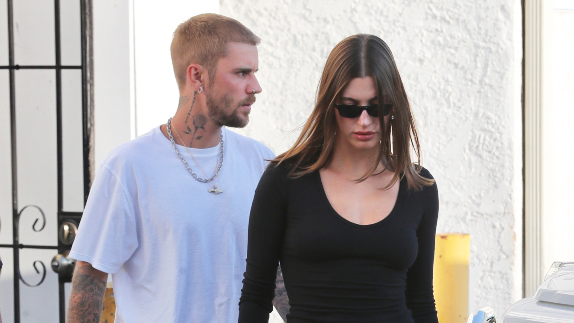 Hailey Bieber wearing a long-sleeve black T-shirt with low-rise white jeans and black leather flip-flops for dinner with Justin Bieber.