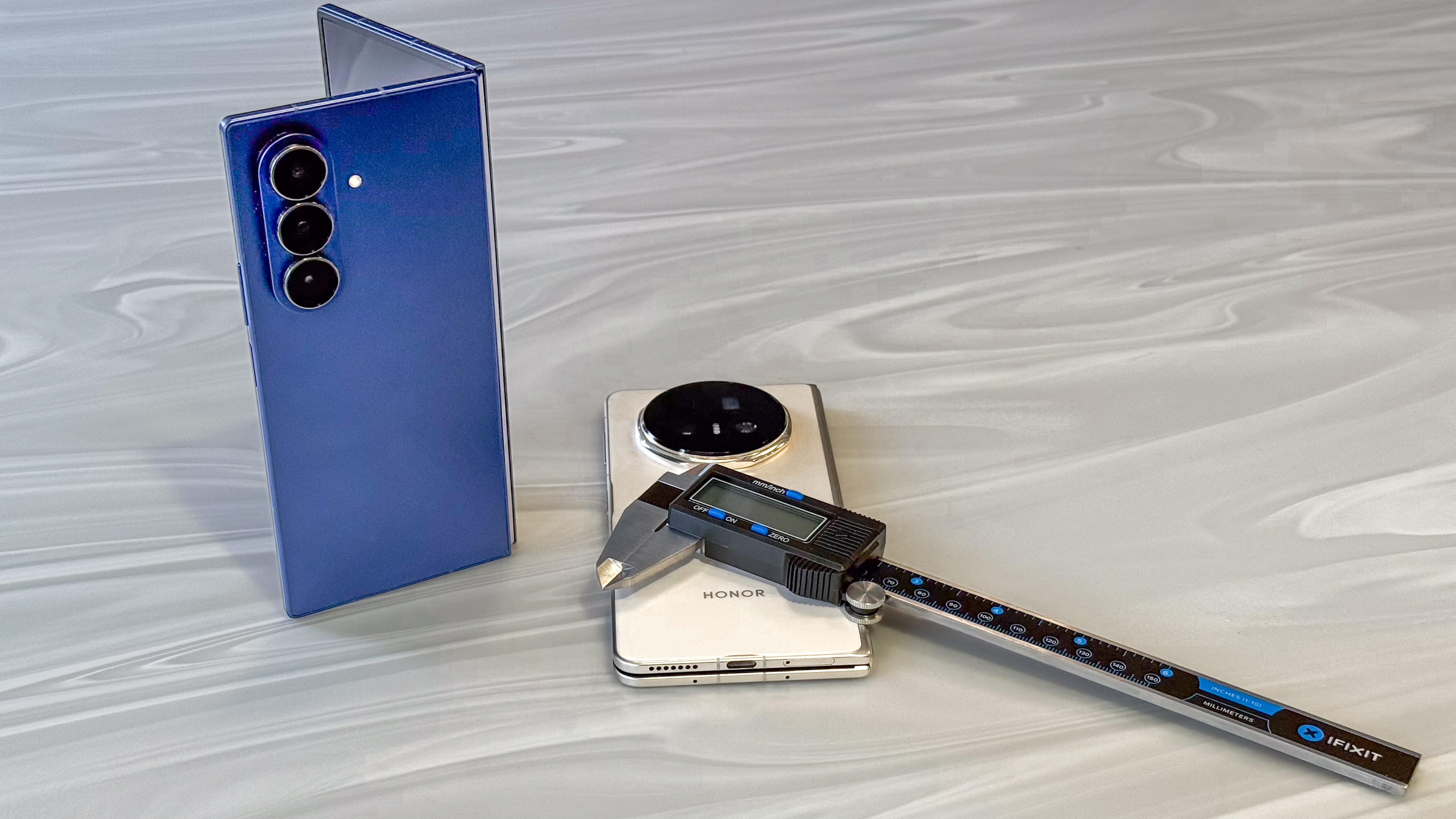 Honor Magic V5 and Samsung Galaxy Z Fold 7 with a set of digital calipers