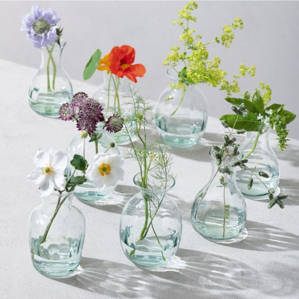 Set of green glass bud vases with flowers in