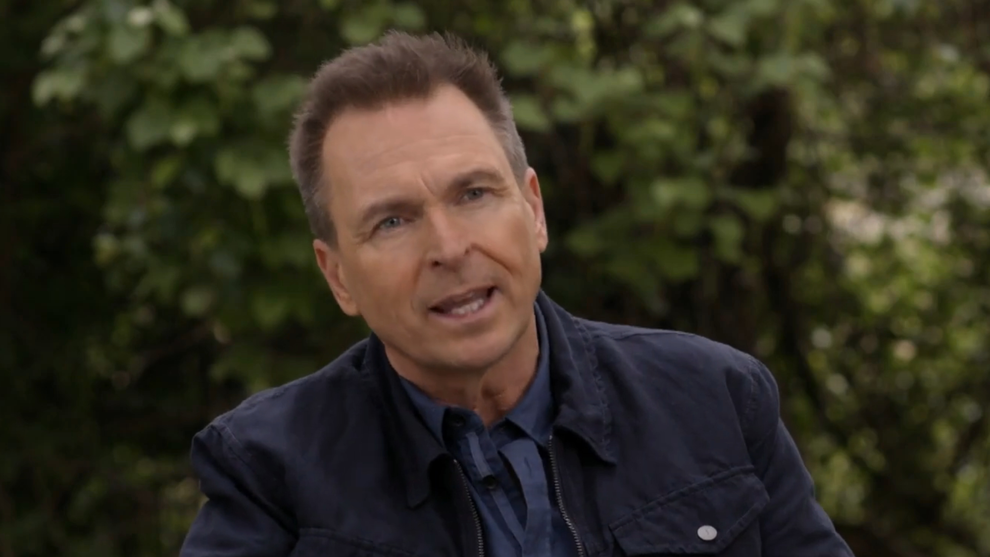 Phil Keoghan gives an interview in a suit while talking about The Amazing Race.