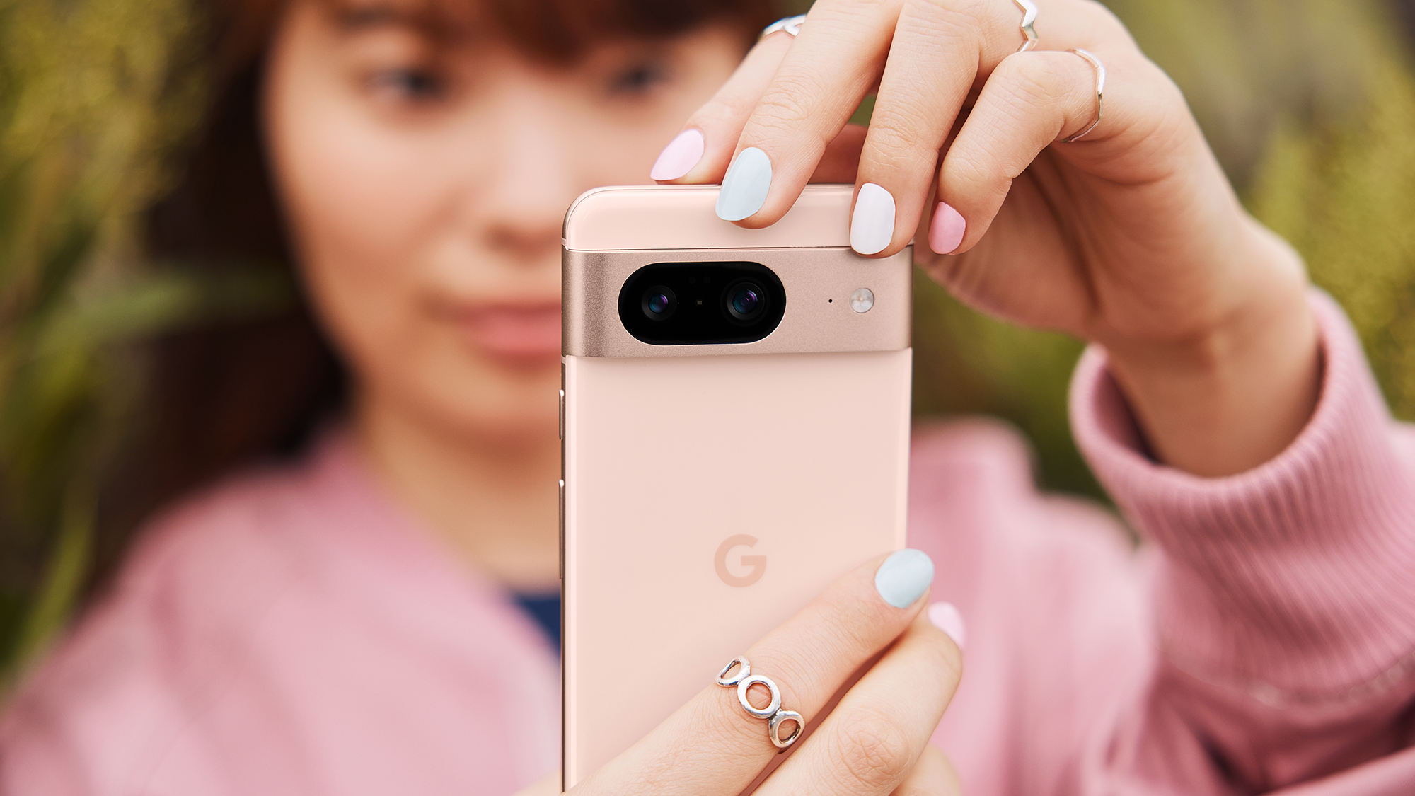 Pressebilde av en person som holder en Google Pixel 8 Rose.