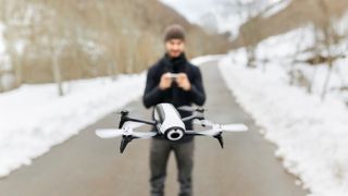 Man navigating a drone in the snowy mountains