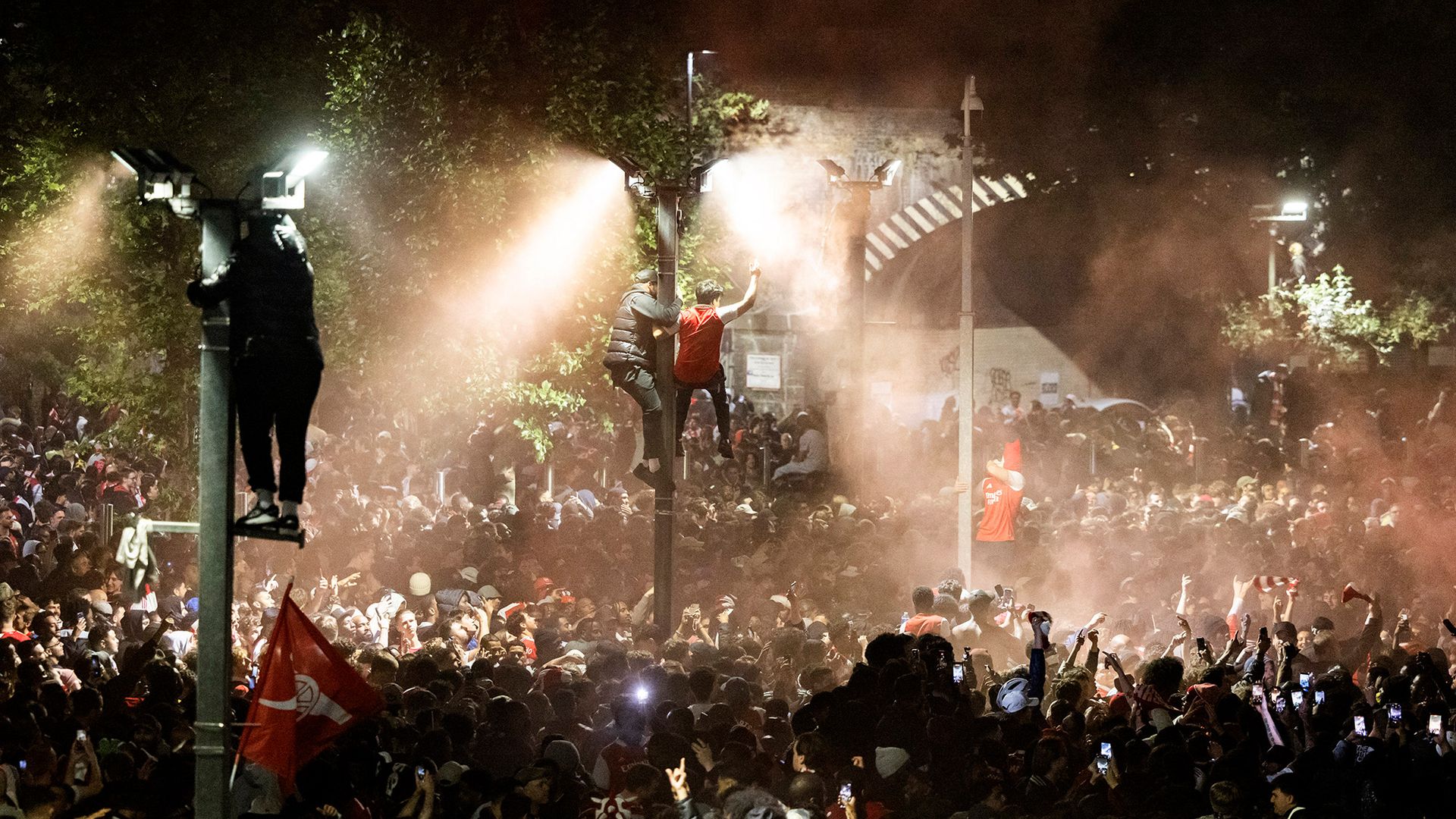 
                                Arsenal fans celebrate their team winning their first English Premier League in 22 years outside the Emirates Stadium in London, UK
                            