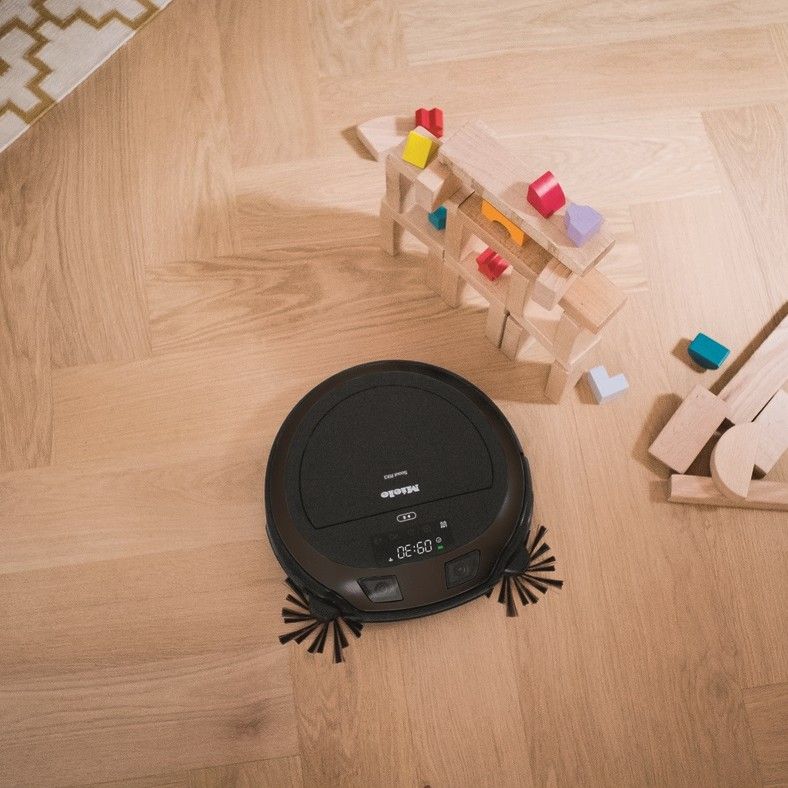 Miele Scout RX3 Home Vision HD on a wooden floor next to children&#039;s wooden building blocks