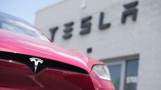 A Model X sports-utility vehicle sits outside a Tesla store