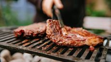 A close-up of a piece of steak being cooked on the grill