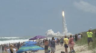 Beachgoers watch as a United Launch Alliance Atlas V rocket launches the SBIRS GEO Flight 5 missile-warning satellite for the U.S. Space Force from Cape Canaveral Space Force Station, Florida on May 18, 2021.
