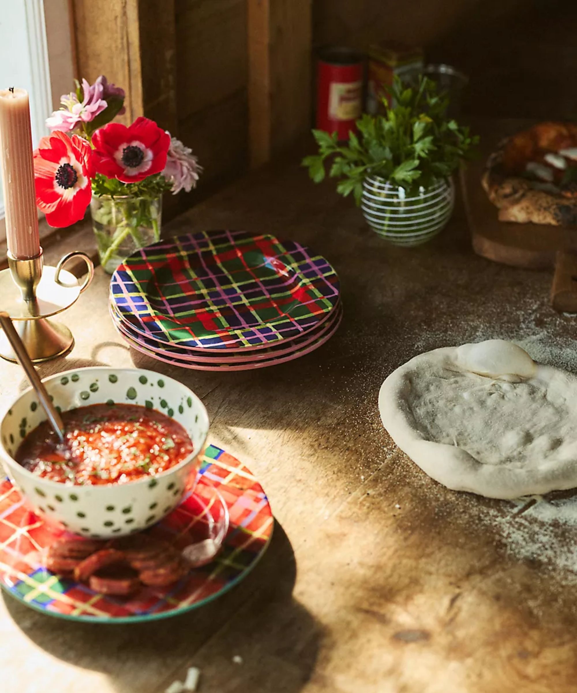 kitchen counter with blockblock mid baking with rolled dough and stacks of tartan plates