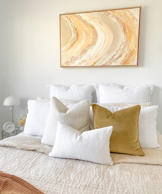A neutral bedroom with abstract vanilla toned art
