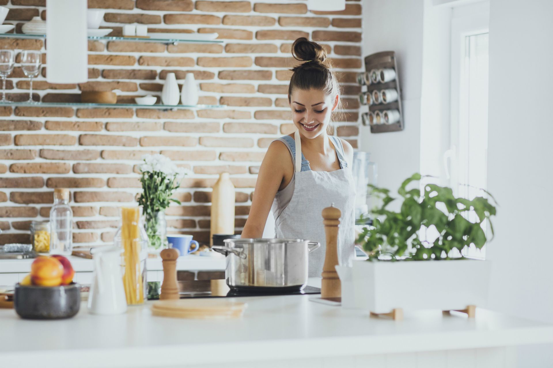 Sustainable eating: a woman in her kitchen cooking with a pan on the hob