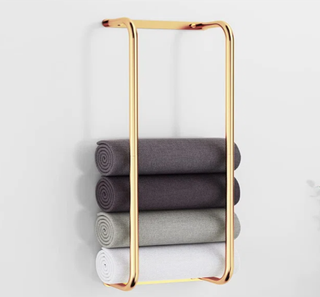 gold towel rack with folded towels inside
