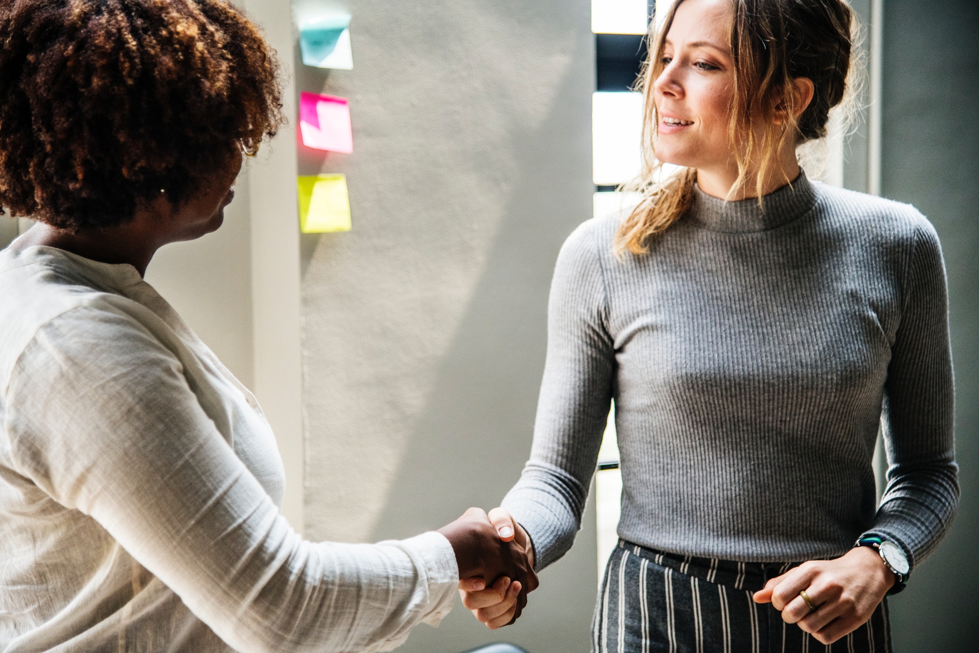 How to get a career in graphic design: Two women shaking hands