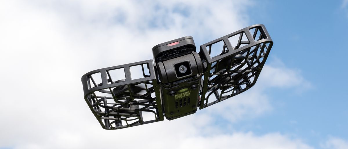 HoverAir X1 flying against a blue sky with white clouds