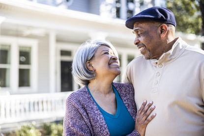 Portrait of senior couple in front of suburban home