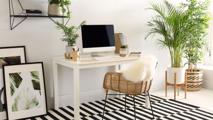 Rattan chair under white desk with computer on