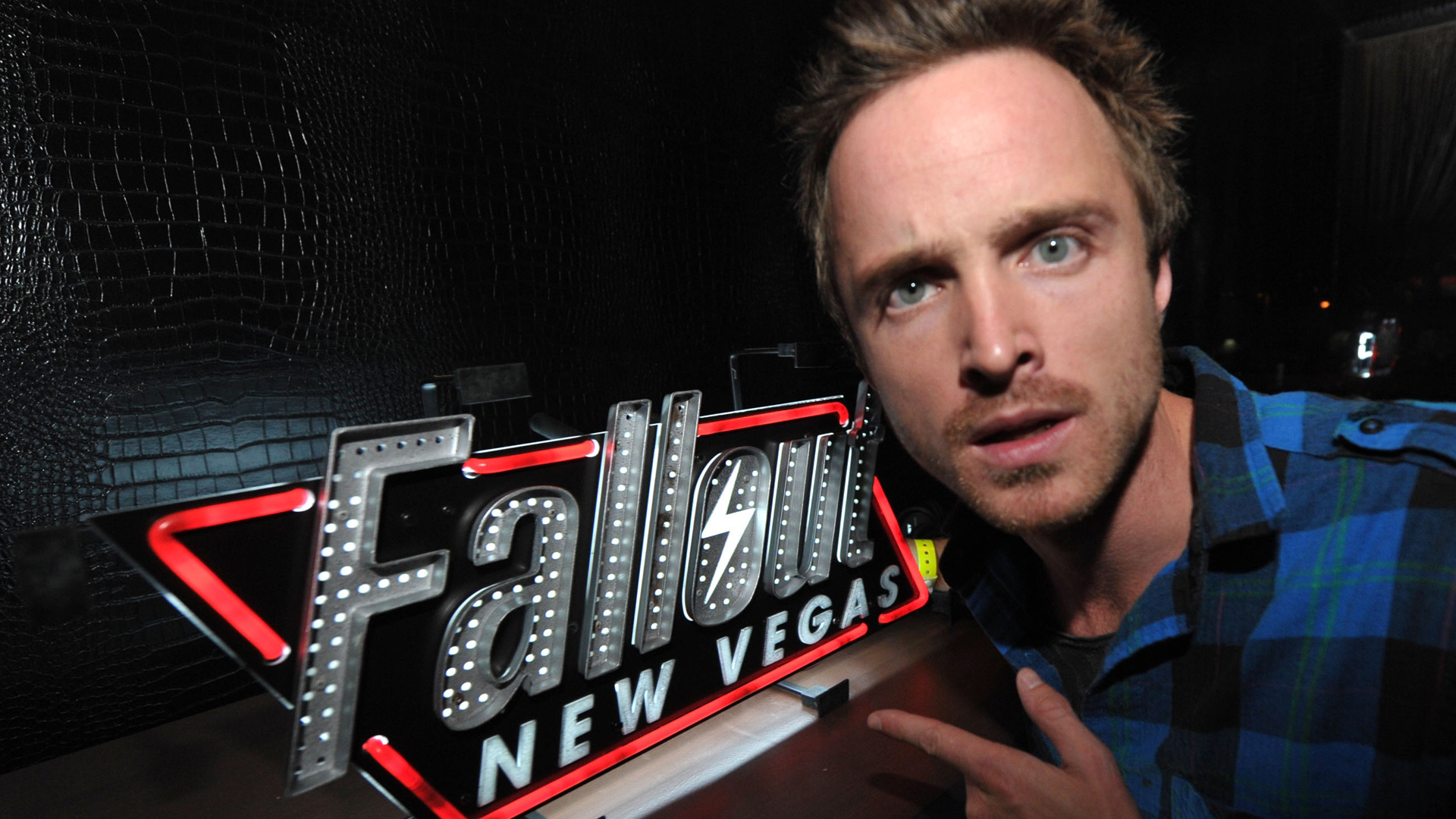 Aaron Paul pointing at a Fallout sign at a Fallout New Vegas launch event in 2010