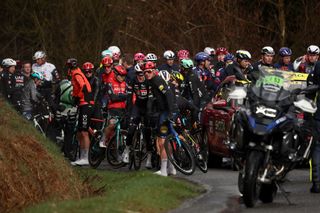 The pack of riders waits for the race to resume as it was neutralised due to weather during the 4th stage of the Paris-Nice cycling race, 163,4 km between Vichy and La Loge des Gardes, on March 12, 2025. (Photo by Anne-Christine POUJOULAT / AFP)