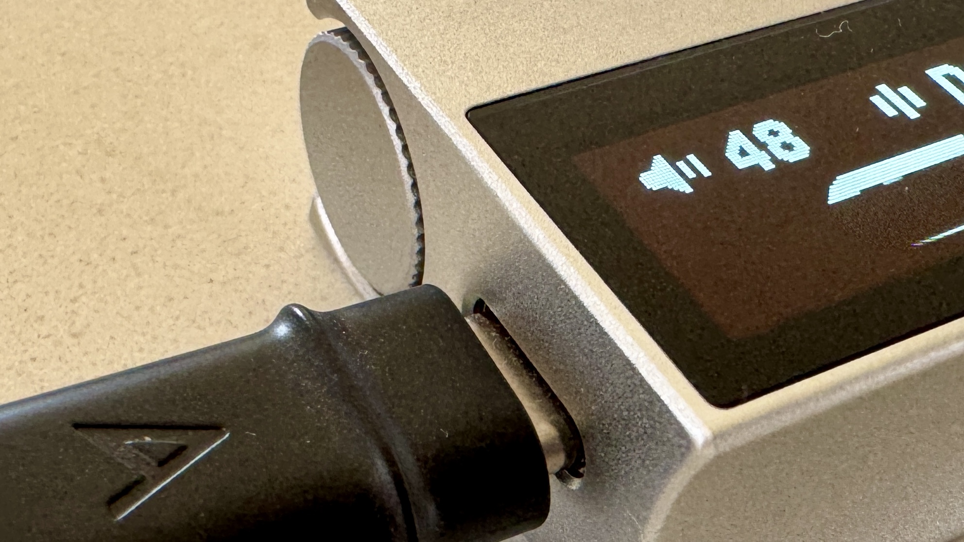 The Astell & Kern AK HC5 on a grey table, with the top plate illuminated and hooked up to Sennheiser IEMs and a FiiO digital audio player