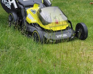 Ryobi 40cm Cordless Brushless Lawn Mower on the grass cutting the lawn