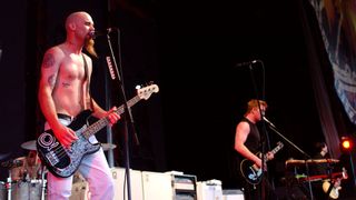 Nick Oliveri playing bass onstage with Josh Homme