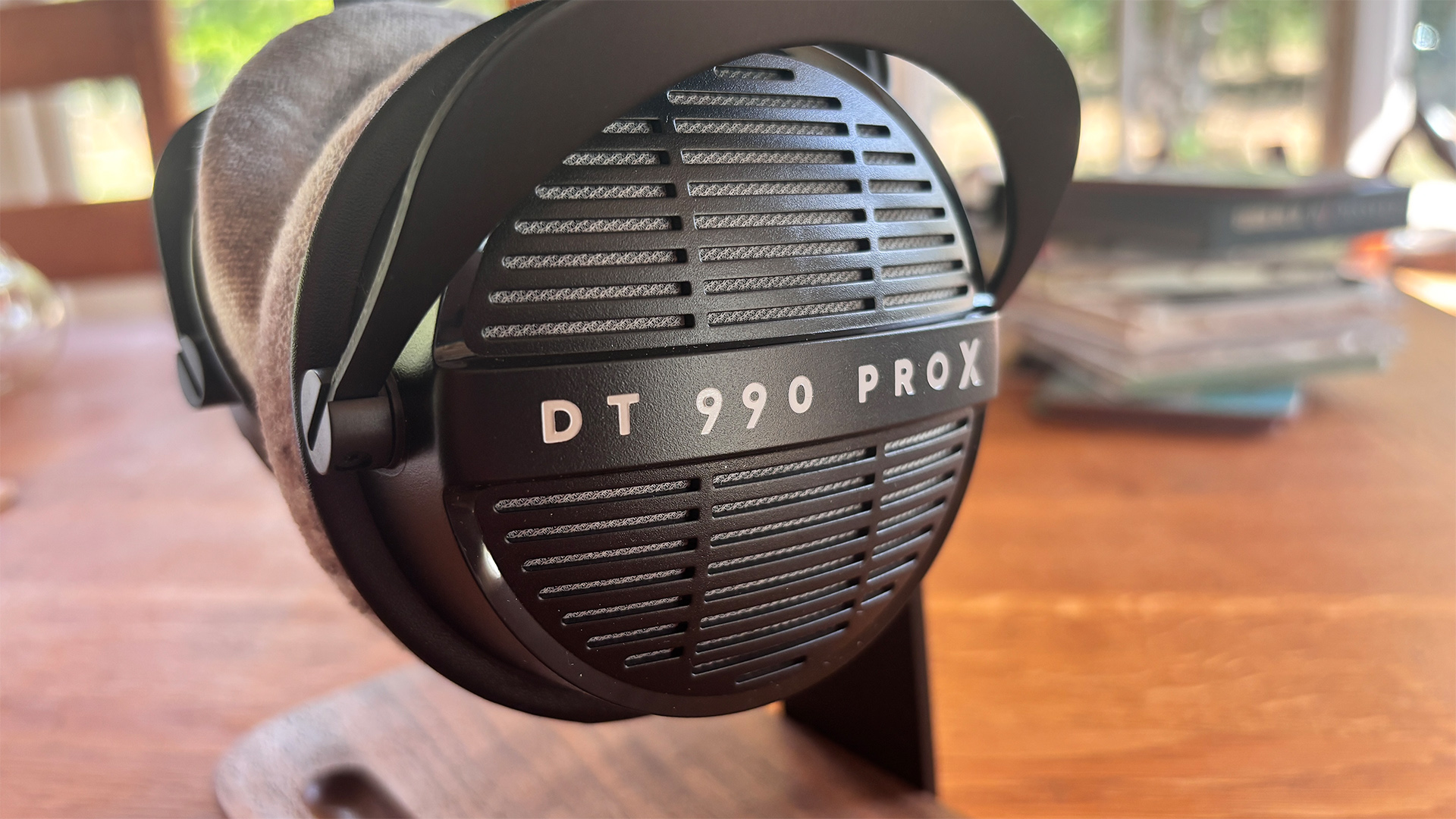 Beyerdynamic DT 990 Pro X wired headphones on wooden table close up on one earcup