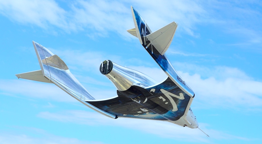 futuristic looking plane soars against a blue sky.