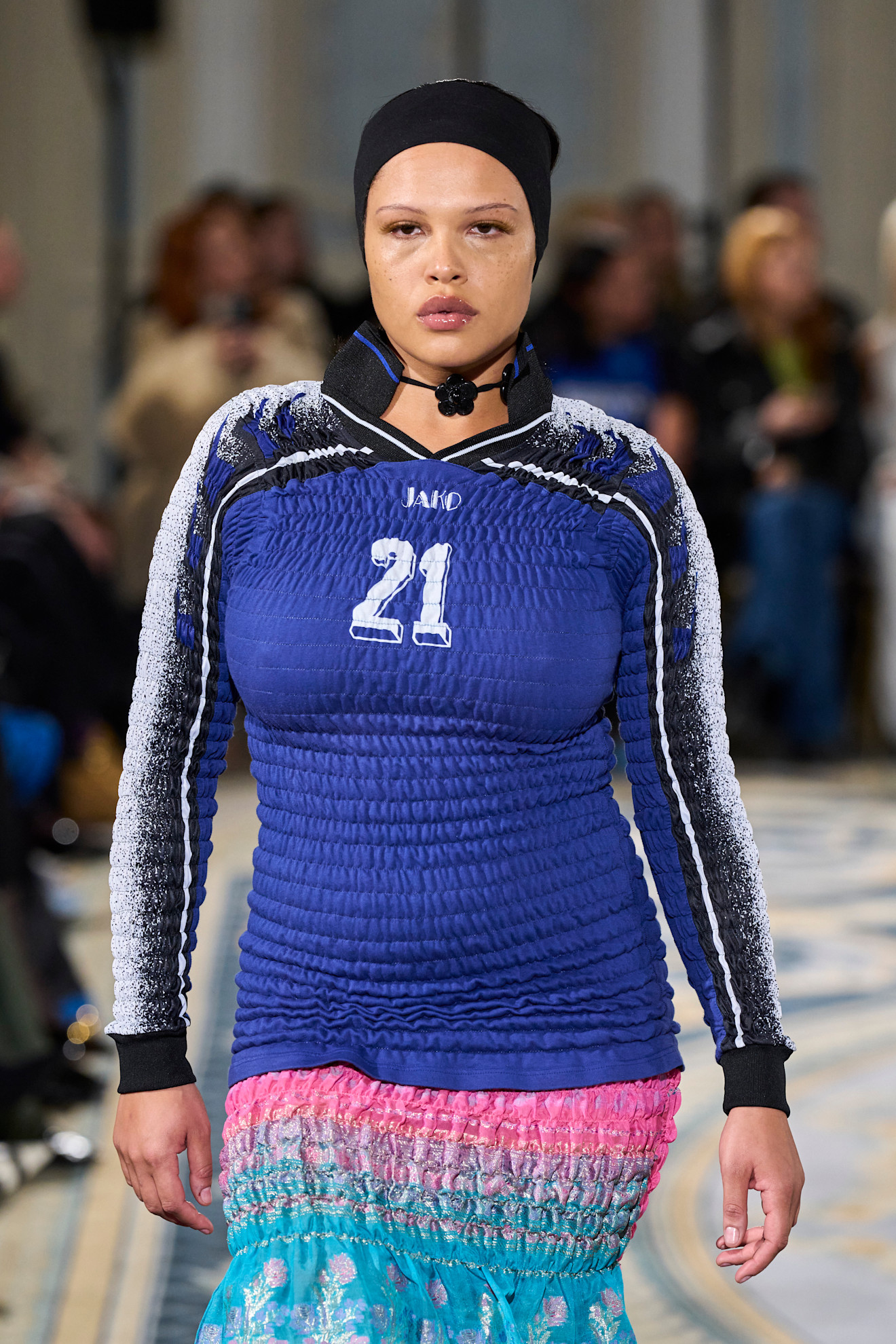 A model wearing a long sleeve blue shirred shirt