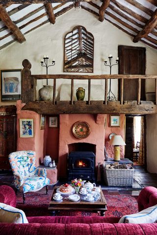 cottage with sofa and stove and beamed ceiling