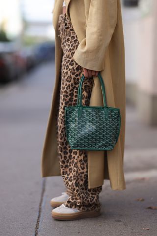 a woman carries a goyard tote in street style