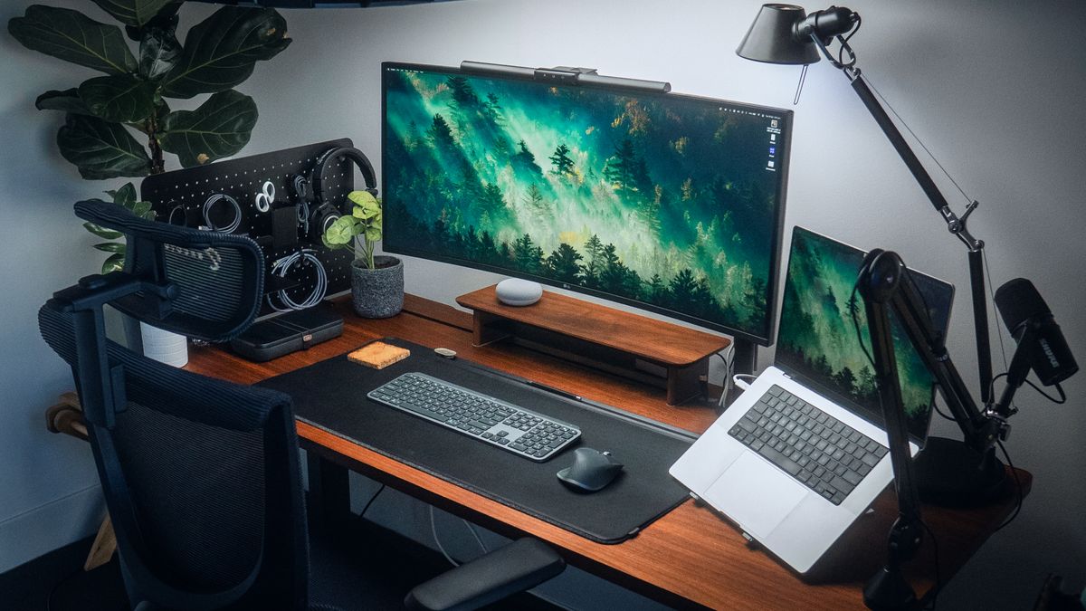 A laptop and monitor screen with accessories on the EverDesk Max