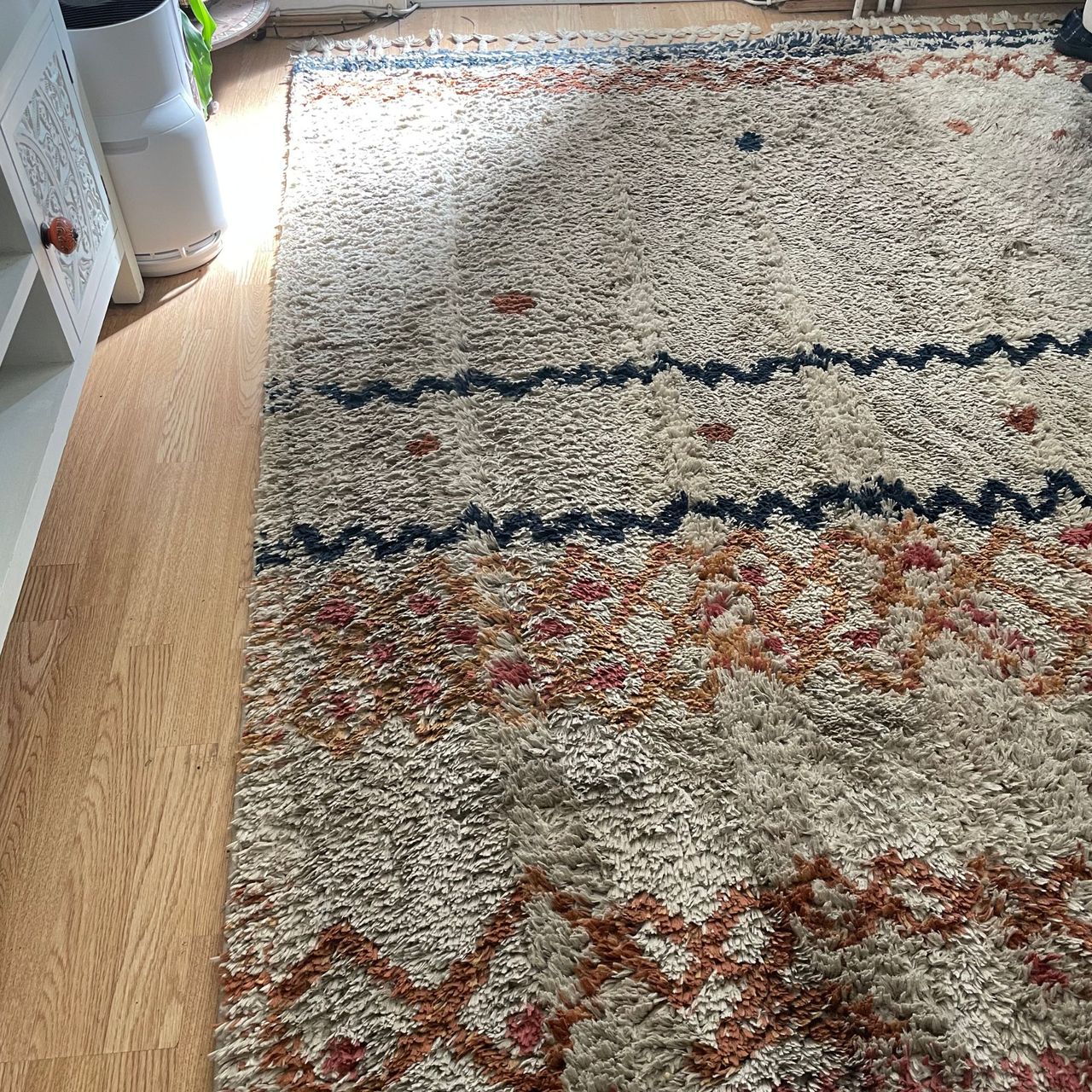 White, orange, and blue berber rug after being cleaned