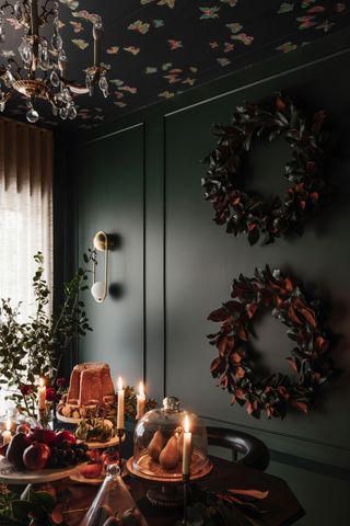 a dark blue dining room decorated for Christmas