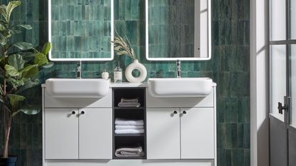 green tiled bathroom with white double sink and mirrors