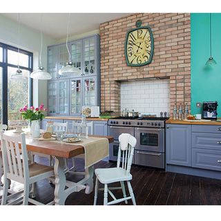 kitchen area with blue wall and cooker with oven and wooden floor and grey cabinets