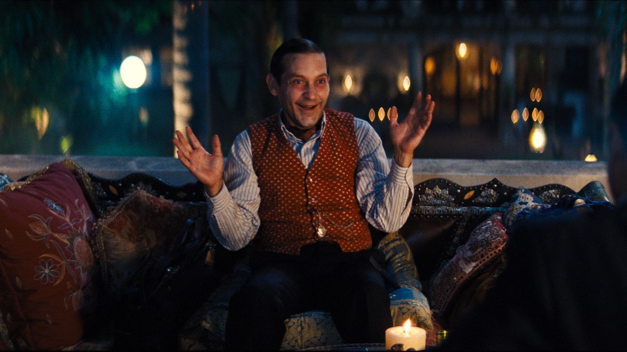Tobey Maguire's James McKay speaks to someone while sitting next to a firepit in Babylon