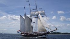 A tall ship sailing on water