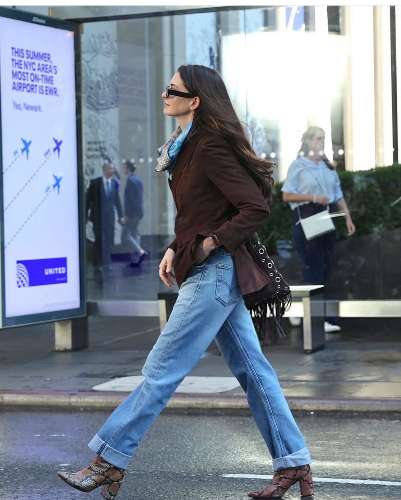 Anne Hathaway in The Devil Wears Prada 2 wearing Levi's vintage denim jeans with a brown suede jacket and snakeskin heeled boots