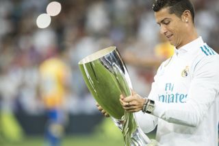 Cristiano Ronaldo checks out the UEFA Super Cup trophy ahead of a Real Madrid game against Valencia in August 2017.