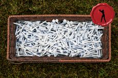 Looking down at a box full of white tees with a red Secret Club Golfer logo in the top-right