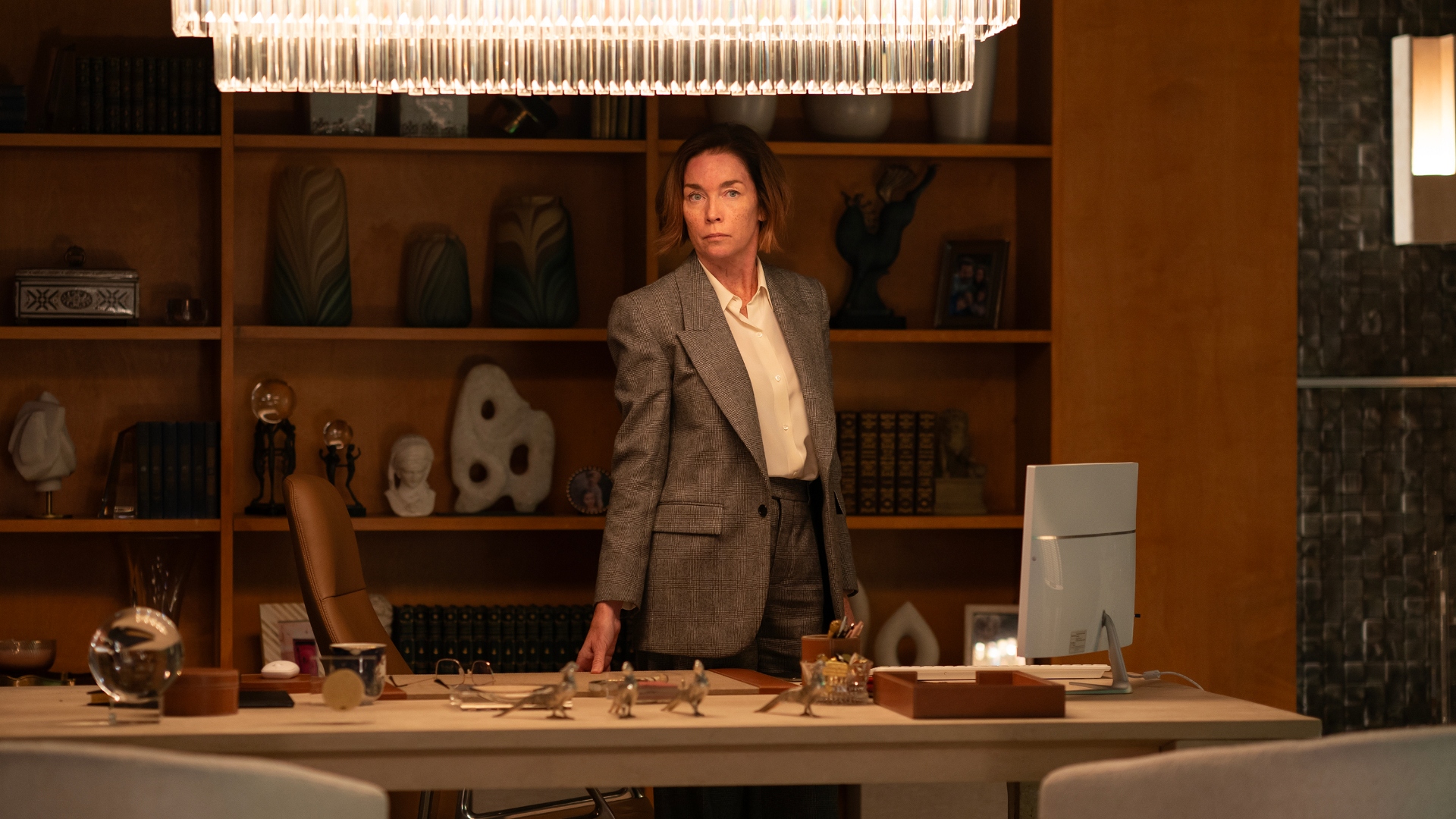 Sinatra stands at her desk in Paradise season 1