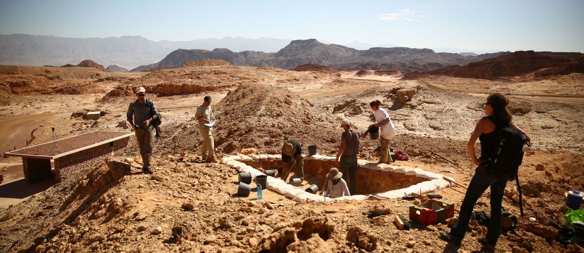 Archaeologists excavate a copper production site dubbed &quot;Slaves&#039; Hill&quot; in the Timna Valley, Israel, with mountains in the background