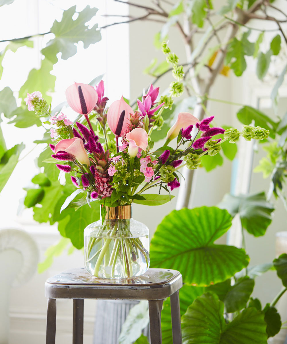 vase with purple flower on brown table