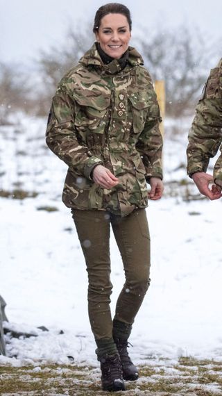 Catherine, Princess of Wales reacts as she walks in the snow while meeting members of the 1st Battalion Irish Guards in 2023