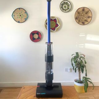 Dyson WashG1 standing on a table in front of colourful baskets