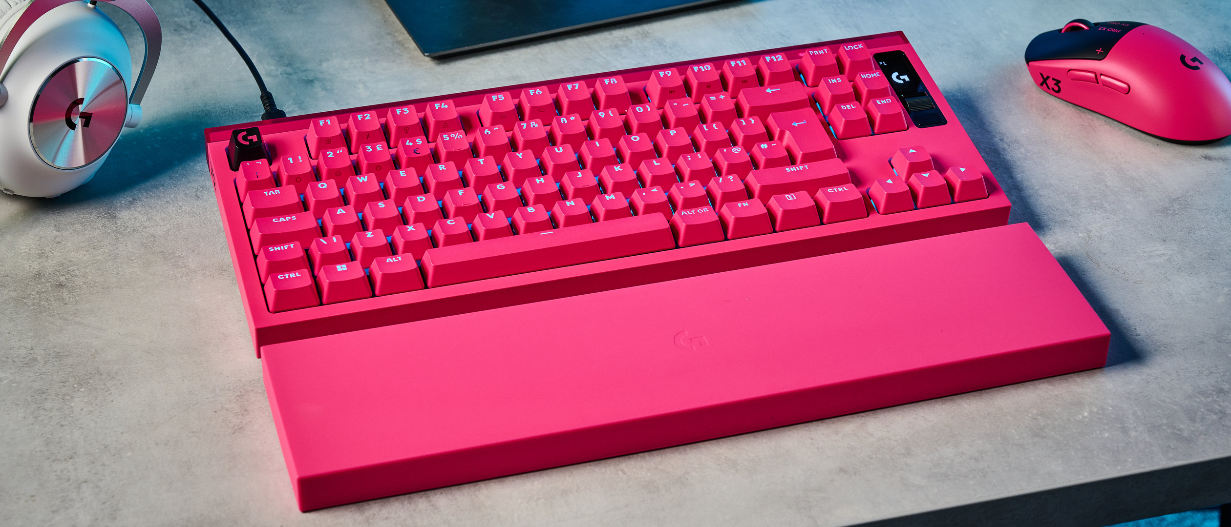 A photo of the Logitech G Pro X2 Rapid keyboard in hot pink on a stone surface