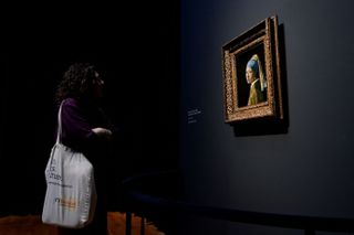 A woman looks at the Vermeer painting "The Girl with a Pearl Earring"
