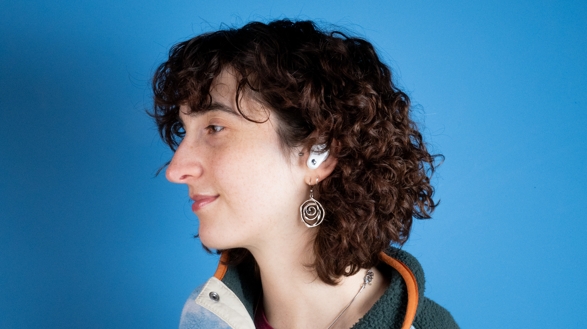 the skullcandy x bose method 360 anc earbuds in white, with a long charging case, a carabiner clip, and various silicone tip sizes